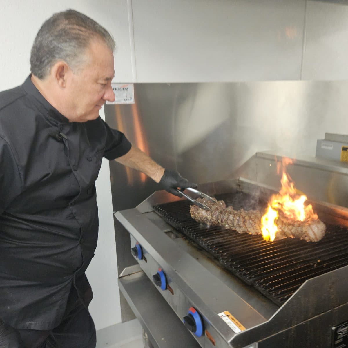 Chef Alan grilling a tenderloin over an open flame