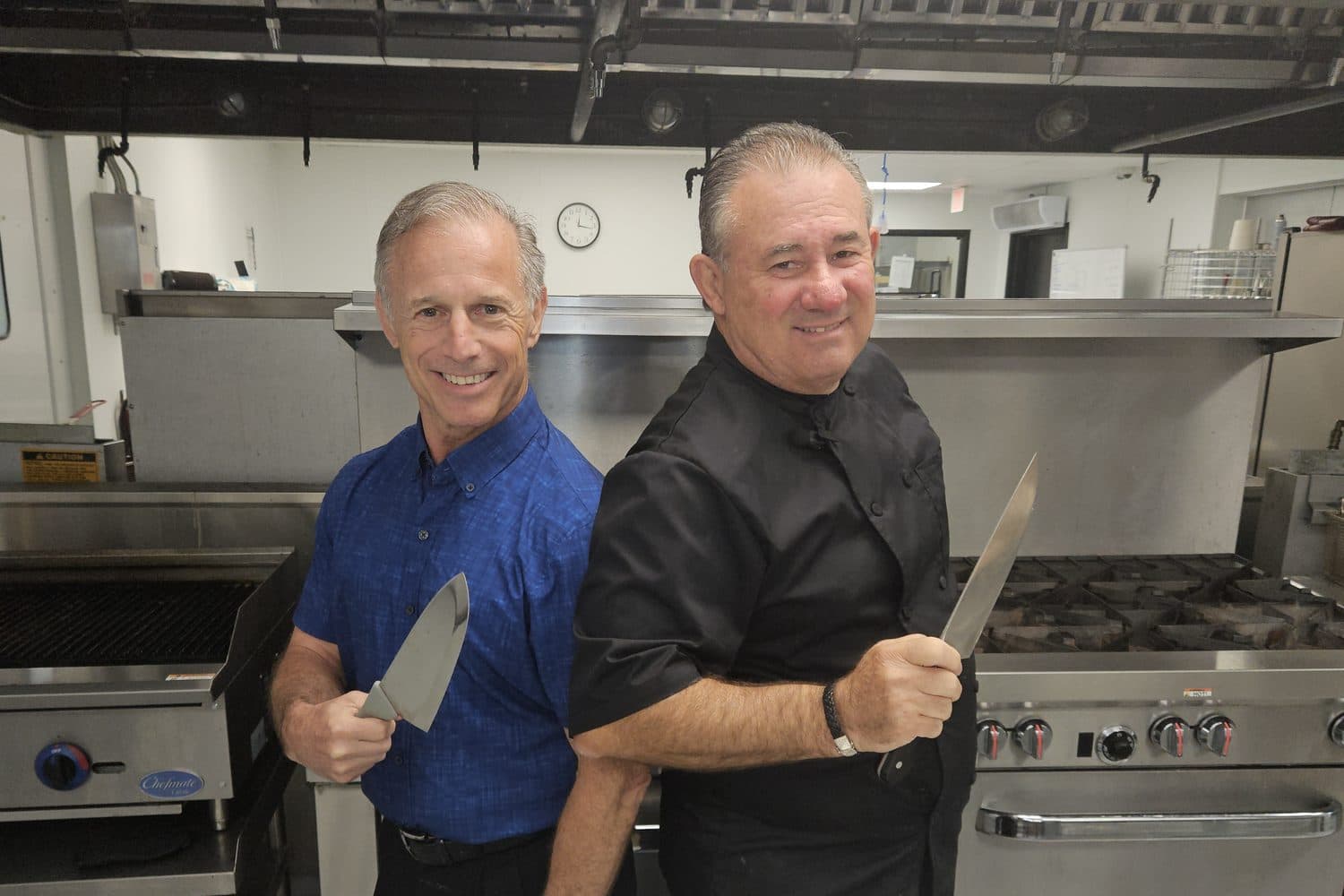 Chef Alan Bergman and Keith Kravitz in the kitchen, knives in hand